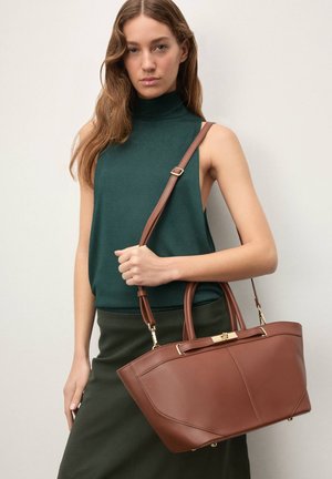 Pruun nahast käekott struktureeritud disainiga, millel on kaks ülemist käepidet ja eemaldatav õlarihm. Kuldse tooniga metalldetailid.