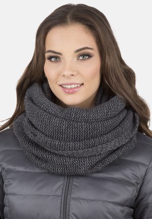 Scaldino grigio a collo alto lavorato a maglia con una texture in filato spesso, drappeggiato in pieghe morbide, abbinato a un giubbotto puff grigio.