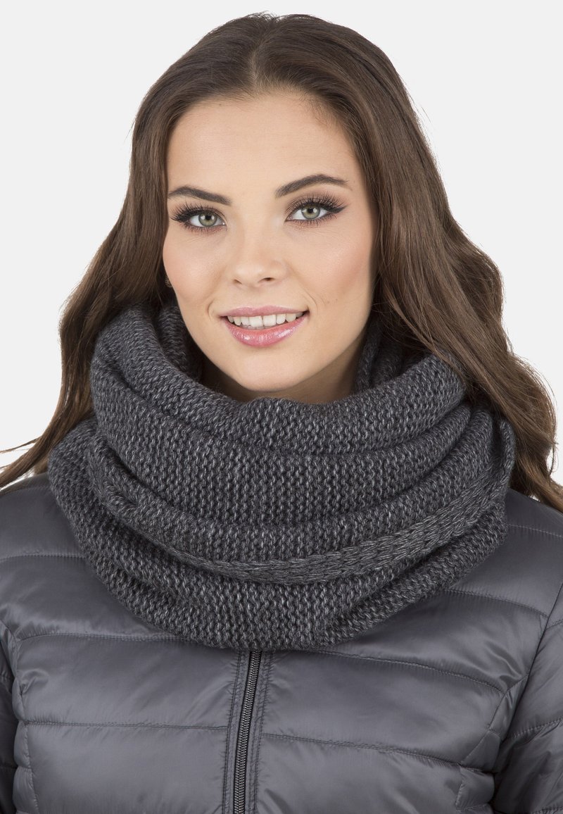 Scaldino grigio a collo alto lavorato a maglia con una texture in filato spesso, drappeggiato in pieghe morbide, abbinato a un giubbotto puff grigio.