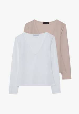 Ensemble de deux chemises à manches longues avec col en V en blanc et beige clair. Tissu en coton mélangé doux avec une texture lisse et un design minimaliste.
