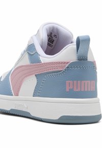 Sneaker bianca con pannelli in pelle blu, striscia rosa, logo "PUMA" sul tallone e colletto imbottito con tag della taglia all'interno.