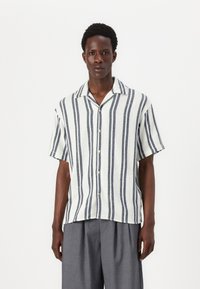 Camisa de manga corta abotonada en tejido ligero con rayas verticales en azul marino y blanco, cuello con muesca y corte relajado.