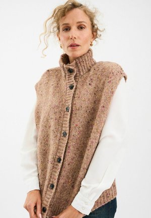 Chaleco de punto marrón con cuello alto, con motas multicolores, siete botones negros en la parte delantera y sin mangas.