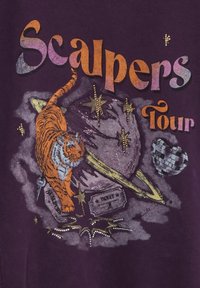 Camiseta gráfica morada con un tigre, estrellas y una bola de discoteca, con texto multicolor que dice "Gira Scalpers". Incluye detalles texturizados.