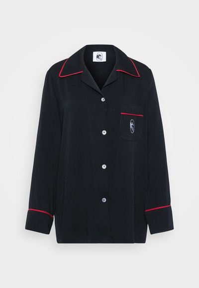 Černá pyžamová košile s červeným lemováním, dlouhými rukávy, výstřihem do klop, pěti knoflíky a náprsní kapsou se znakem na látce.