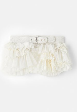 Balti raukšlėta sijonas su sluoksniuota medžiaga, nėrinių akcentais ir nėriniuotais diržais, kuriuose yra metalinis sagtis ir snapų užsegimai.