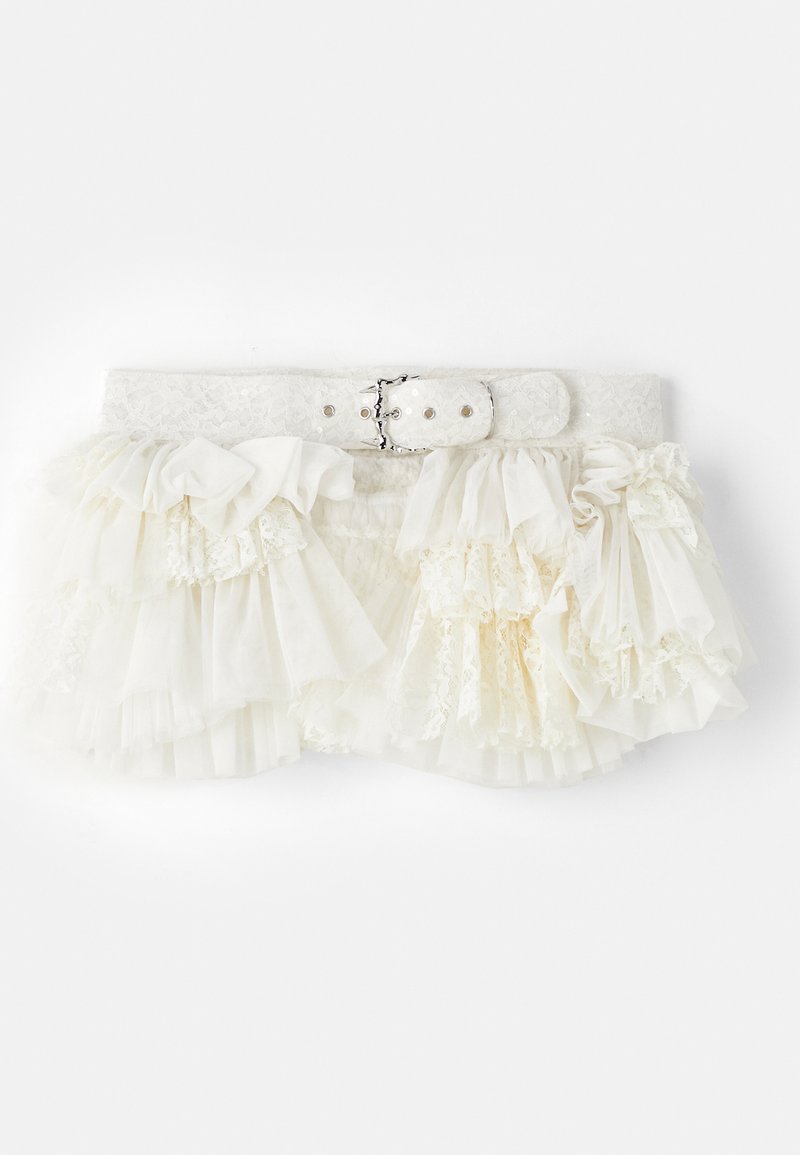 Hvid rynket nederdel med lagdelt stof, blonder og et bælte med blondestrimler, der har en metalspænde og trykknapslukninger.