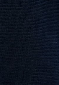 Tissu en maille bleu marine foncé avec une texture côtelée serrée et uniforme et un motif de tissage de fil fin.