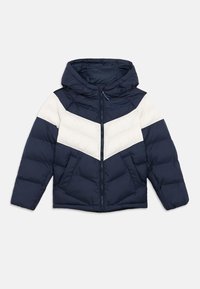 Navy blue puffer jacket with white chevron stripes, hood, and zip closure. Features two front pockets and stitched puffed texture.