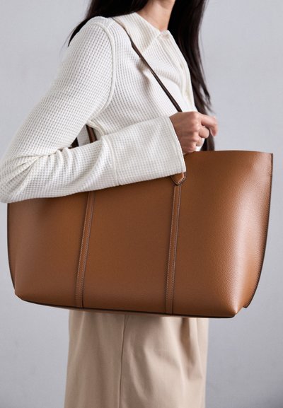 Sac fourre-tout en simili cuir marron avec une texture lisse, doté de trois coutures verticales et d'une longue bandoulière fine.