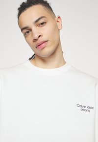 Calvin Klein Jeans FLOWER LOGO RELAXED CREW NECK - Sweatshirt - bright white