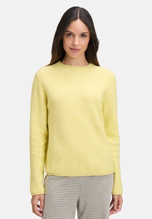Geel geribbeld sweater met een ronde hals en lange mouwen, gemaakt van zachte stof. Gecombineerd met een geruite broek.