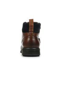 Boot in pelle marrone con tomaia in suede blu, con linguetta sul retro e suola in gomma nera. Caratterizzato da una texture liscia e un design neutro.