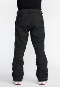 Black snowboarding pants featuring a relaxed fit, adjustable waistband, two side pockets, and a smooth texture, designed for comfort and mobility.