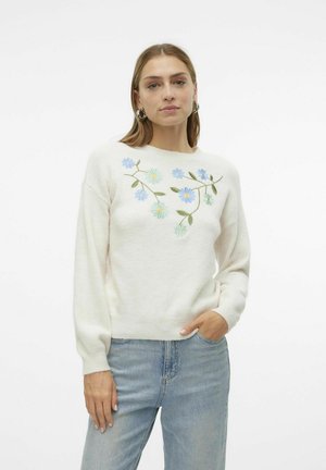 Crème-kleurige sweater van zachte stof, met blauwe en groene bloemenborduursels over de borst, en met geribbelde manchetten en zoom.