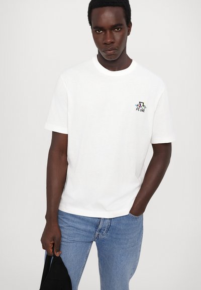 Camiseta de algodón blanca de manga corta, con un pequeño gráfico colorido de una bicicleta y el texto "PS ONE" en el lado izquierdo del pecho.