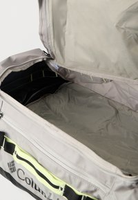 Η τσάντα τύπου duffel της Columbia διαθέτει ανοιχτό γκρι εξωτερικό, μαύρο εσωτερικό και φερμουάρ. Έχει ευρύχωρο διαμέρισμα και ρυθμιζόμενους ιμάντες.