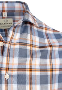 Męska koszula w kratę w kolorze niebieskim, białym i pomarańczowym. Posiada klasyczny kołnierzyk, zapięcie na guziki oraz miękką tkaninę.