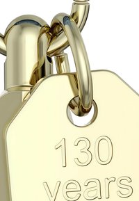 Zlatá štítok s zaoblenými hranami, na ktorom je vygravírovaný text "130 rokov." Obsahuje kruhový otvor a lesklý povrch.