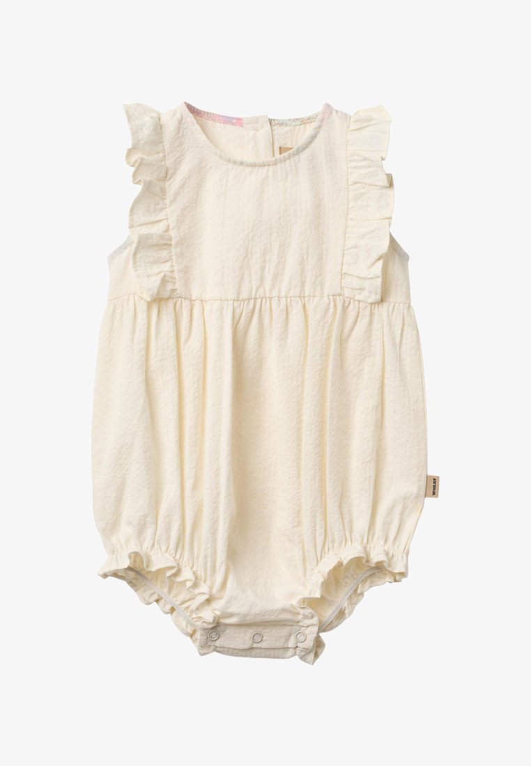 Combinaison pour bébé couleur crème avec manches à volants, taille froncée et boutons-pression à l'entrejambe pour faciliter le changement de couche.