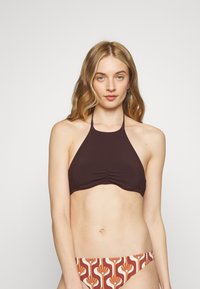 Top de bikini castanho com alças, com detalhe franzido, combinado com parte de baixo de bikini estampada, apresentando estampas florais em laranja, vermelho e creme.