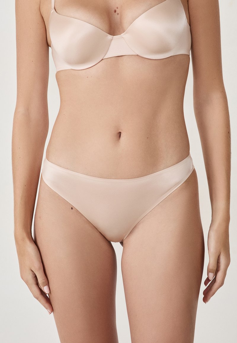 Nude satin bra and panties set with a seamless design, soft texture, and delicate straps, featuring minimal hardware and no visible patterns.