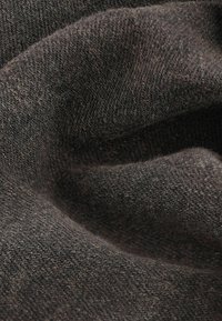 Tejido de punto marrón oscuro con una superficie suave y texturizada. El material tiene un aspecto ligeramente difuso y un caído suave y fluido.