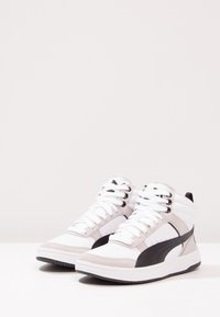 High-Top-Sneaker in Weiß, Grau und Schwarz. Aus glattem Leder und Wildleder, mit runder Zehenform, dicker Sohle und auffälligem Seitenlogo.