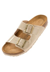 Sandalo con due fibbie in materiale sintetico lucido beige; plantare in sughero con texture marrone; dettagli dorati sulle cinghie regolabili.