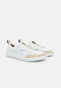 Baskets blanches avec une tige en maille texturée, des accents en suède beige et une semelle en caoutchouc flexible. Comprend un design à lacets et une languette au talon.