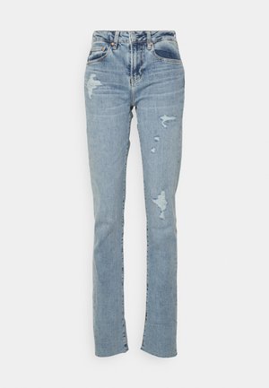 Svetlo modri skinny jeans z poškodbami na kolenih in stegnu, sprednji žep in zanke za pas so vidni.