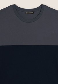 Camiseta de algodón con cuello redondo, diseño a bloques de color en azul marino oscuro y gris, con textura suave y etiqueta con el logo de Freddy.