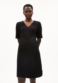Schwarzes Kurzarmkleid mit V-Ausschnitt, strukturiertem Schnitt und glatter Textur. Verfügt über dezente Nähte entlang der Säume.