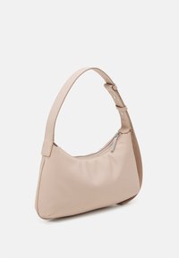 Borsa hobo in morbido materiale beige con forma curva. Presenta una singola tracolla regolabile e una chiusura con zip dotata di hardware argentato.