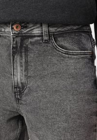 Grå denimjeans med en subtil tekstur, som har en kobberknap, standardlommer og klassisk femlommers design.