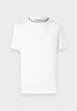 T-shirt blanc à manches courtes et col rond avec un fin liseré noir autour du col et un texte de marque subtil à l'intérieur du col.