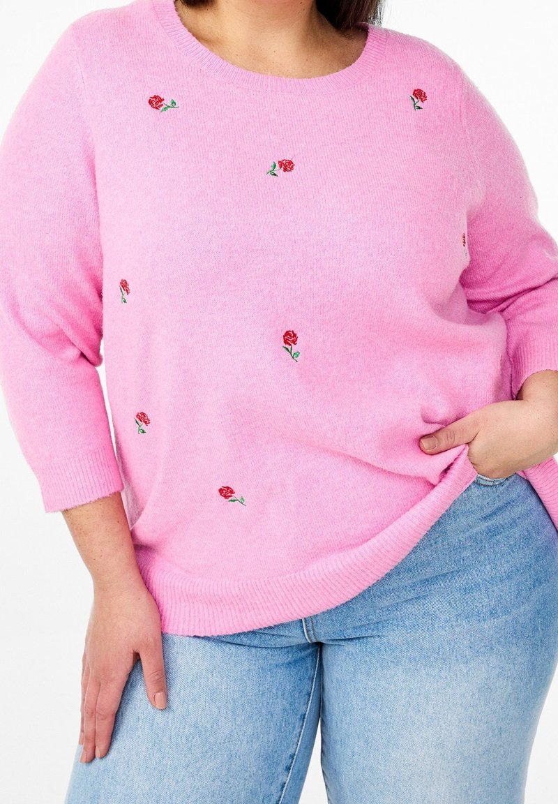 Rosa gestrickter Pullover mit gestickten roten Rosen, rundem Ausschnitt und dreiviertellangen Ärmeln. Weiche Textur mit geripptem Saum.
