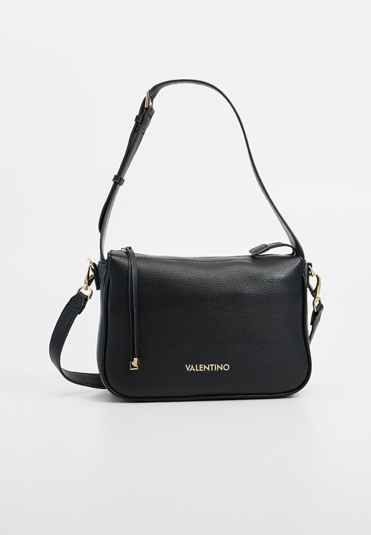 Sac à bandoulière en cuir noir avec marquage doré, dotée d'une texture lisse, d'une bandoulière réglable et d'une fermeture éclair avec un détail de pompon sur le côté.