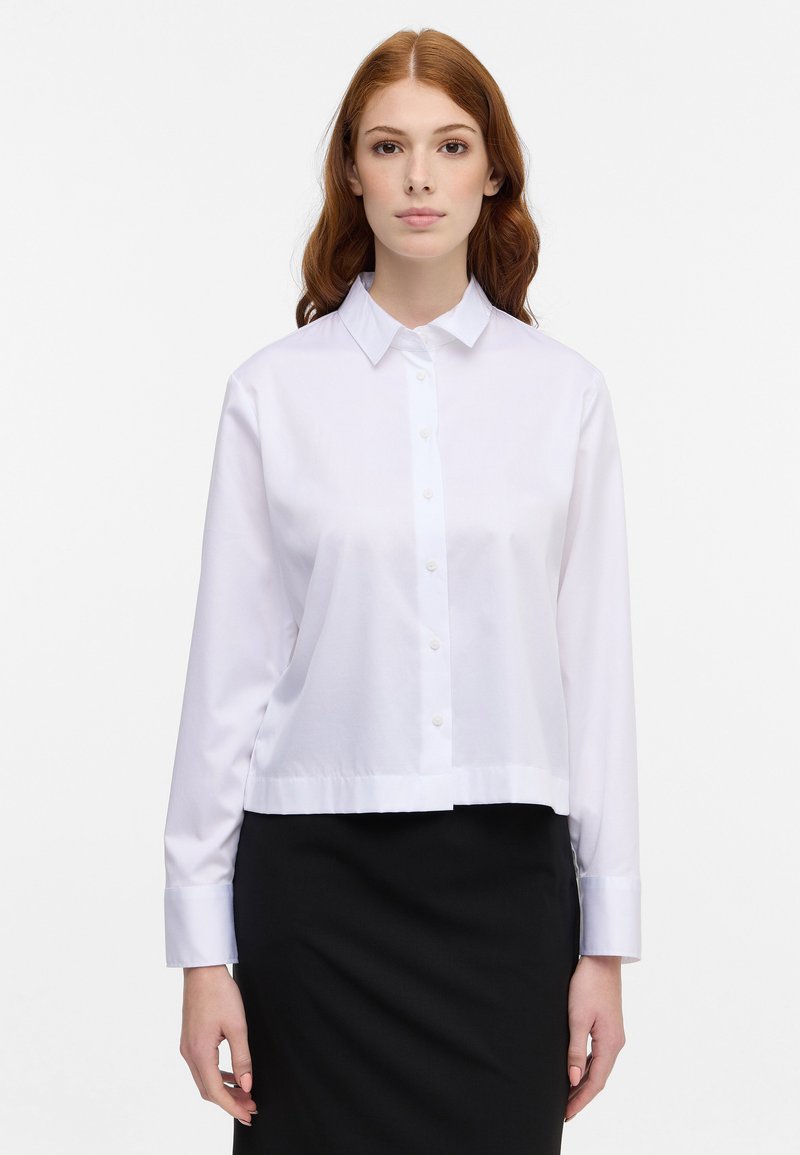 Witte katoenen knoopshirt met lange mouwen, een kraaghalslijn en een cropped zoom; stof lijkt glad en lichtgewicht.