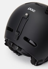 Schwarzer mattschwarzer Helm mit Belüftungsöffnungen, verstellbarem Verschluss und einer Halterung für Zubehör, mit aufgedrucktem Logo an der Seite.