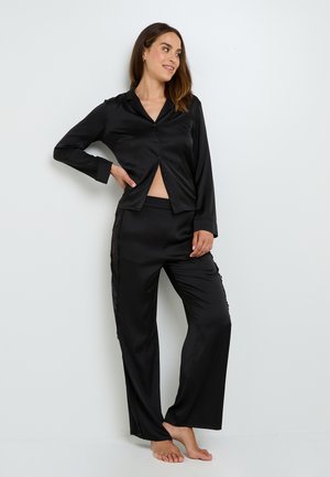 Ensemble de pyjama en satin noir à deux pièces comprenant un haut à manches longues avec boutons et un pantalon à jambes larges avec des accents en dentelle sur les côtés.