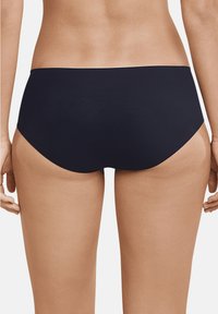 Parte inferiore di bikini nera con una texture liscia, taglio a vita bassa e cintura elastica, che presenta un design minimalista senza motivi visibili.