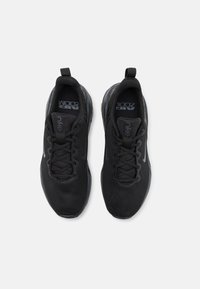 Musta urheilukengät, joissa on verkkopinta, nauhakiristys ja Nike-logo. Varustettu Air-yksiköllä pehmustusta varten ja teksturilla varustettu pohja pitoa varten.