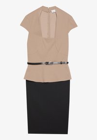 Beige top s krátkými rukávy a hlubokým V-výstřihem, v kombinaci s upnutou černou sukní. Obsahuje černý kožený pásek v pase.