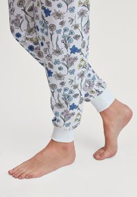 Broek van zachte stof, met een kleurrijk bloemenpatroon op een lichte achtergrond, met witte elastische boorden en een relaxte pasvorm.