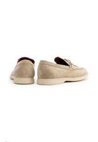 Scarpe in suede beige con punta rotonda, dettagli in pizzo e suola in gomma. La parte posteriore presenta un sottile design a cucitura.