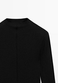 Black knit top featuring a high neckline, long sleeves, and a central back seam for a fitted look. Smooth texture, minimalistic design.