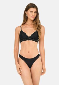 Sort blonde bralette med bølget kant og justerbare stropper, parret med en simpel sort tanga trusser, der fremhæver en glat tekstur.