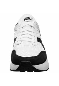 Sneaker sportivo bianco e nero con tomaia in rete, dettagli in suede, punta tonda, chiusura con lacci e logo Nike sul linguetta.