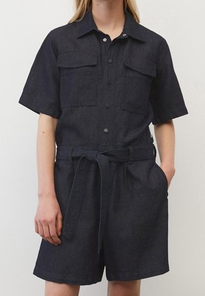 Ciemny kombinezon z denimu z krótkimi rękawami, kołnierzem, zapinany na guziki z przodu, dwoma kieszeniami na piersiach i wiązanym paskiem w talii. Wykonany z fakturowanej tkaniny.
